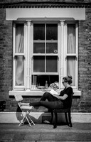 Columbia Road resident reading in street bw
