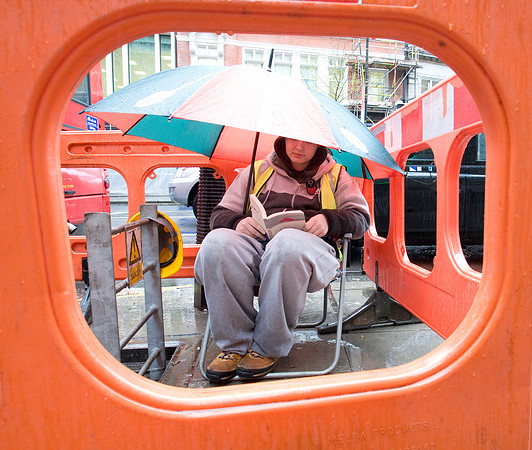 Telecom worker taking a break in the rain