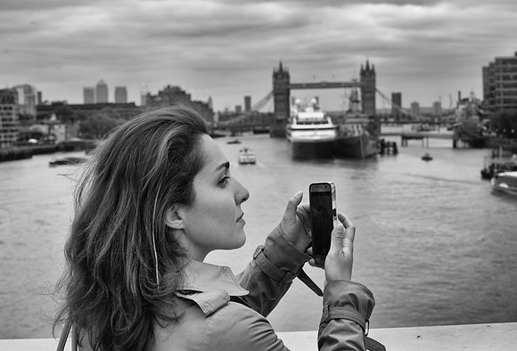 Tower Bridge female tourist with smartphone