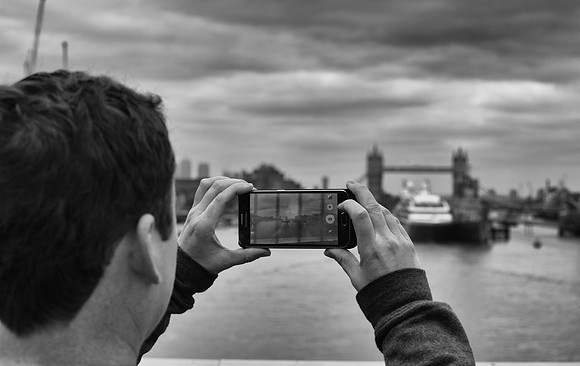 Tower Bridge male tourist with smartphone