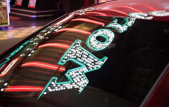 Southend neon reflected in red car