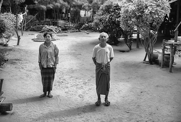 Burmese couple in their yard bw