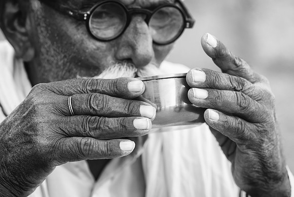 Rohet Garh village elder hands drinking bw