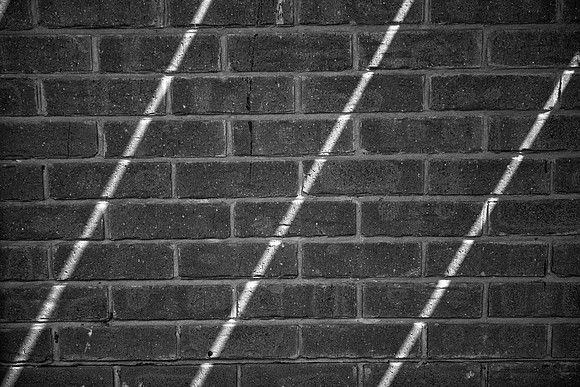 Sunlight stripes on brick BW